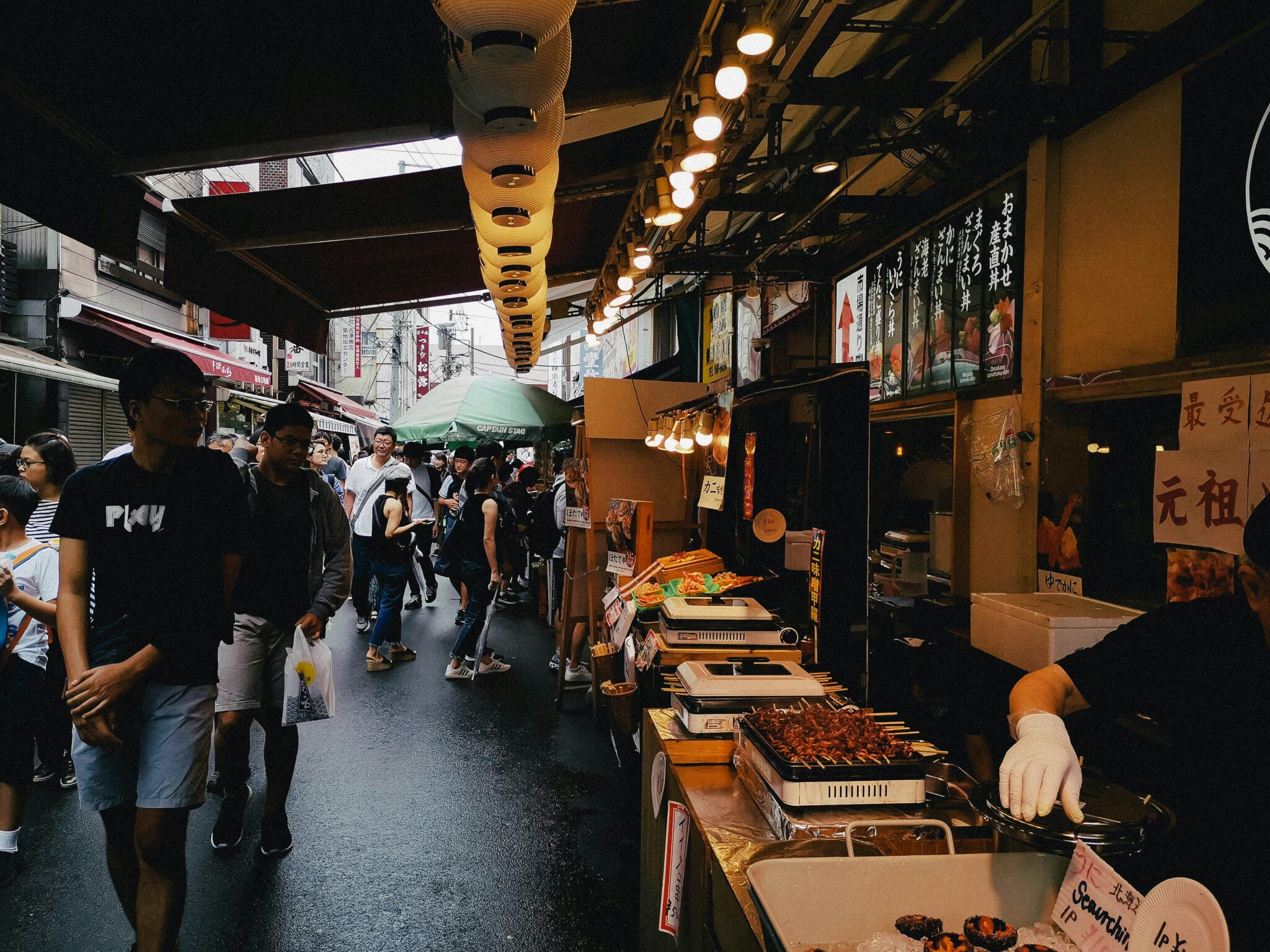 marché Tsukiji avec des touristes passant devant les stands.