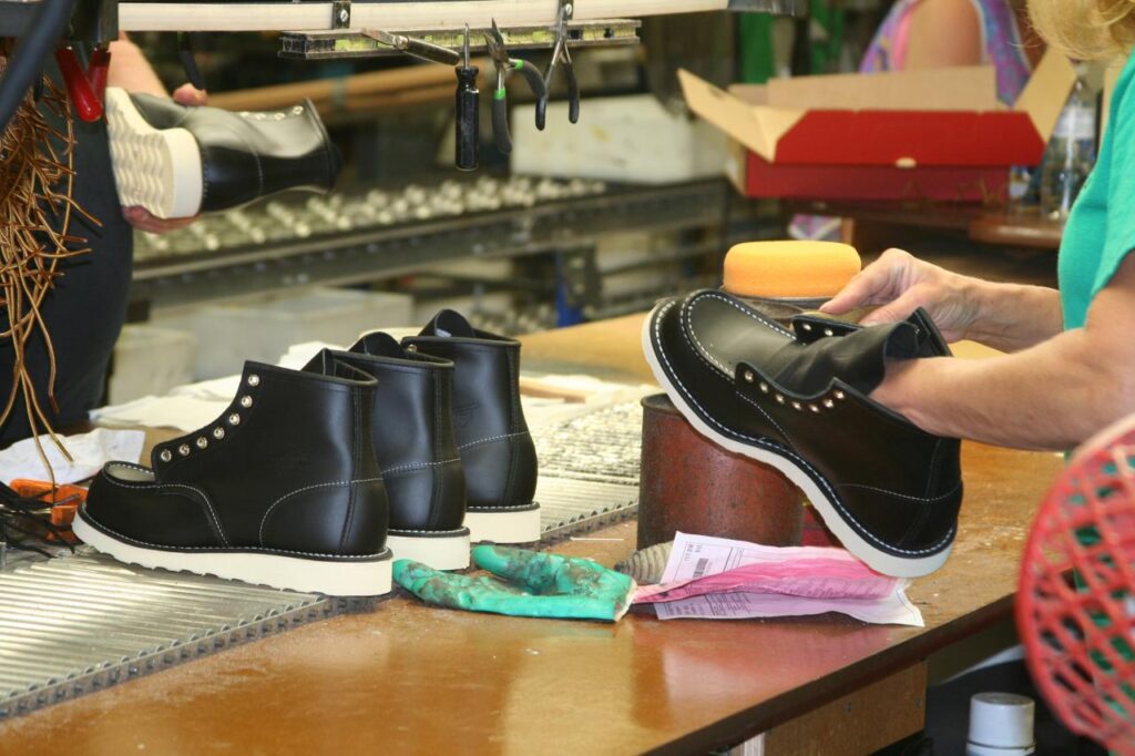 personne cirant des chaussures dans une usine