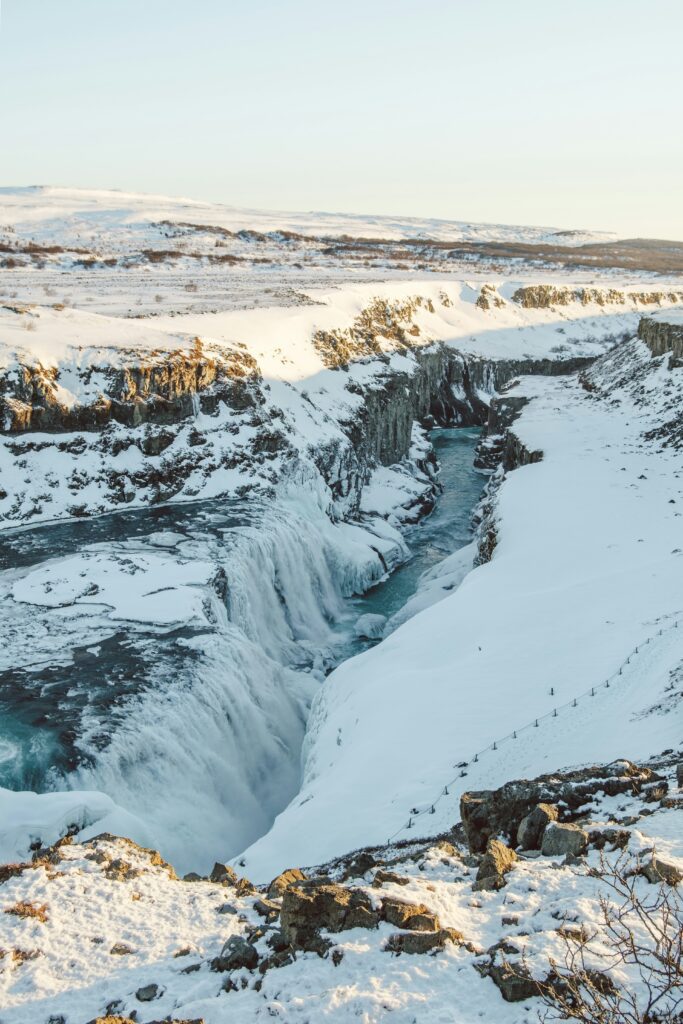 ruisseau passant au milieu de plaines enneigées en Islande.