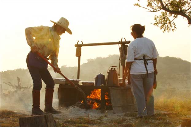 Une femme et homme prepant le feu pour un barbecue texan