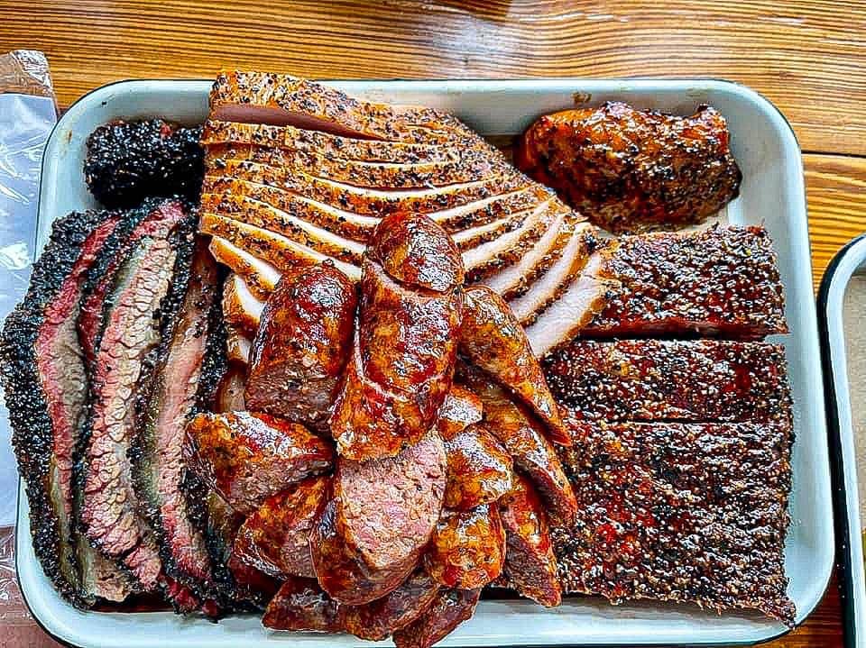 Platea de viande cuite au BBq avec plusieurs types de viandes.