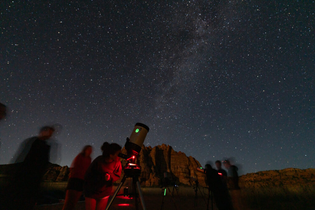 Observationdes étoiles la nuit par des touristes avec des téléscopes.
