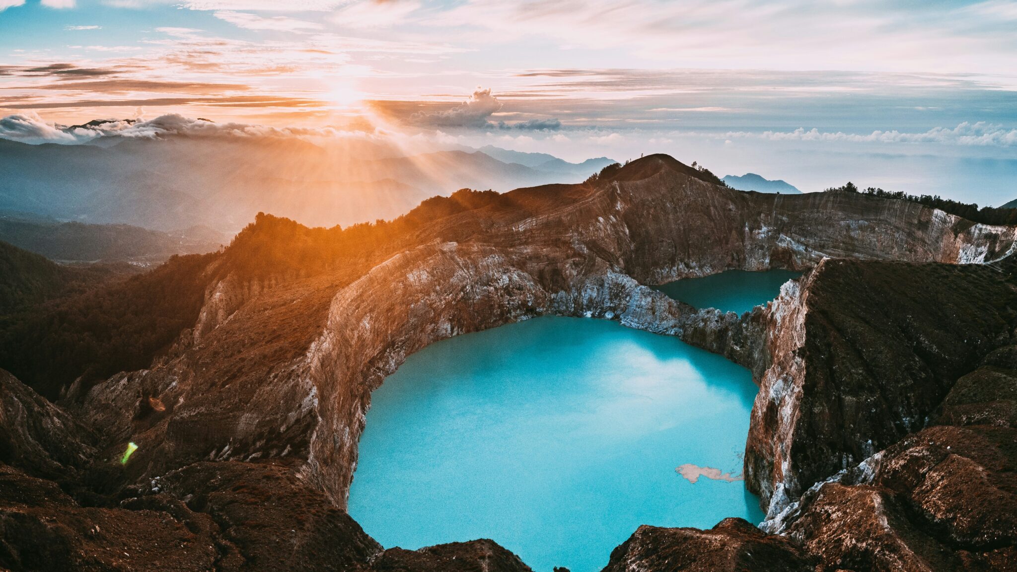 Vue de haut du Lac Kelimutu avec le levé de soleil en fond.