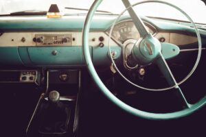Intérieur d'une voiture vintage bleue clair. Zoom sur le volant et la radio.