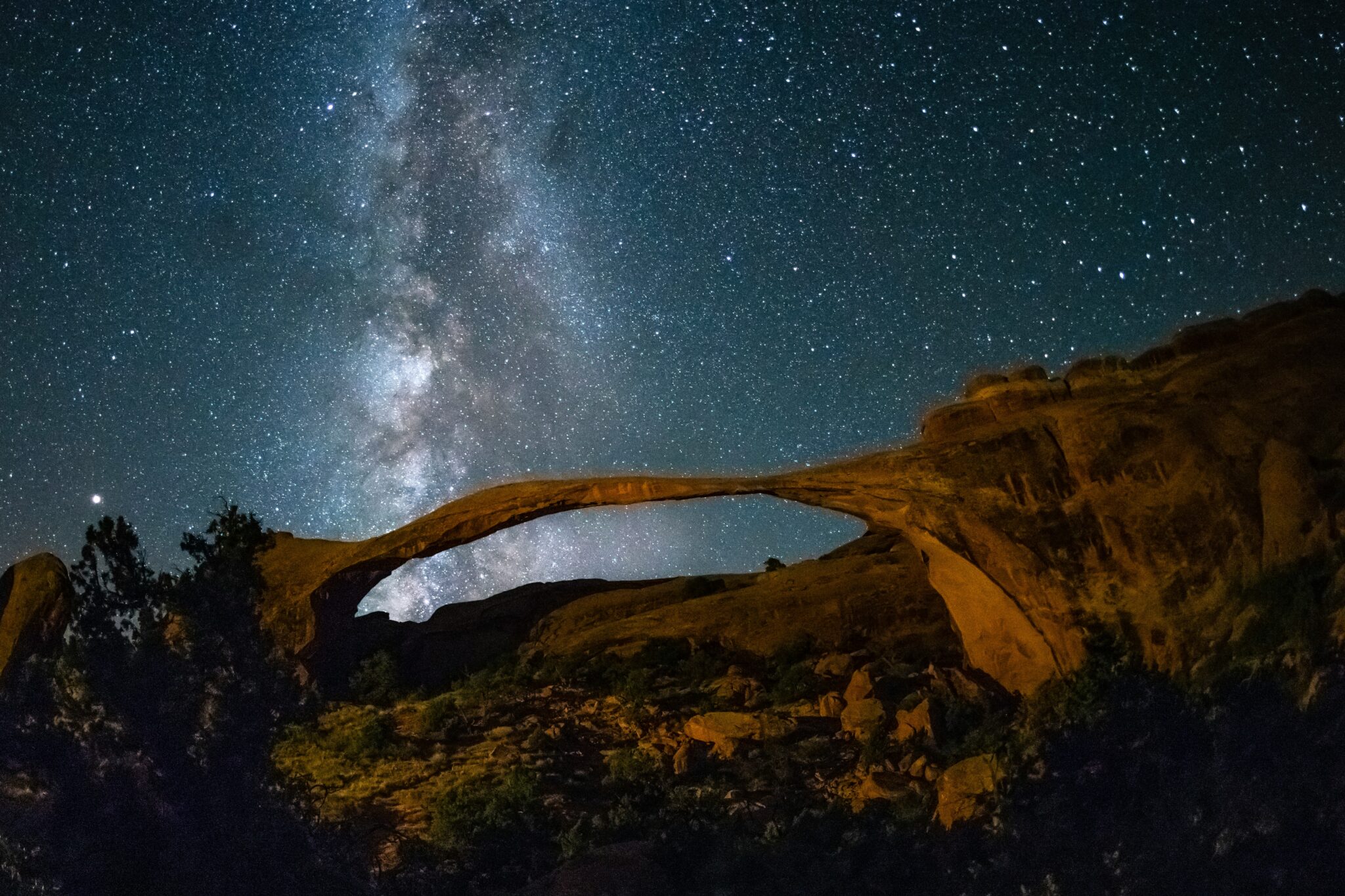 Etoiles visibles par nuit et un pont naturel encadrant au Natural Bridges National Monument.