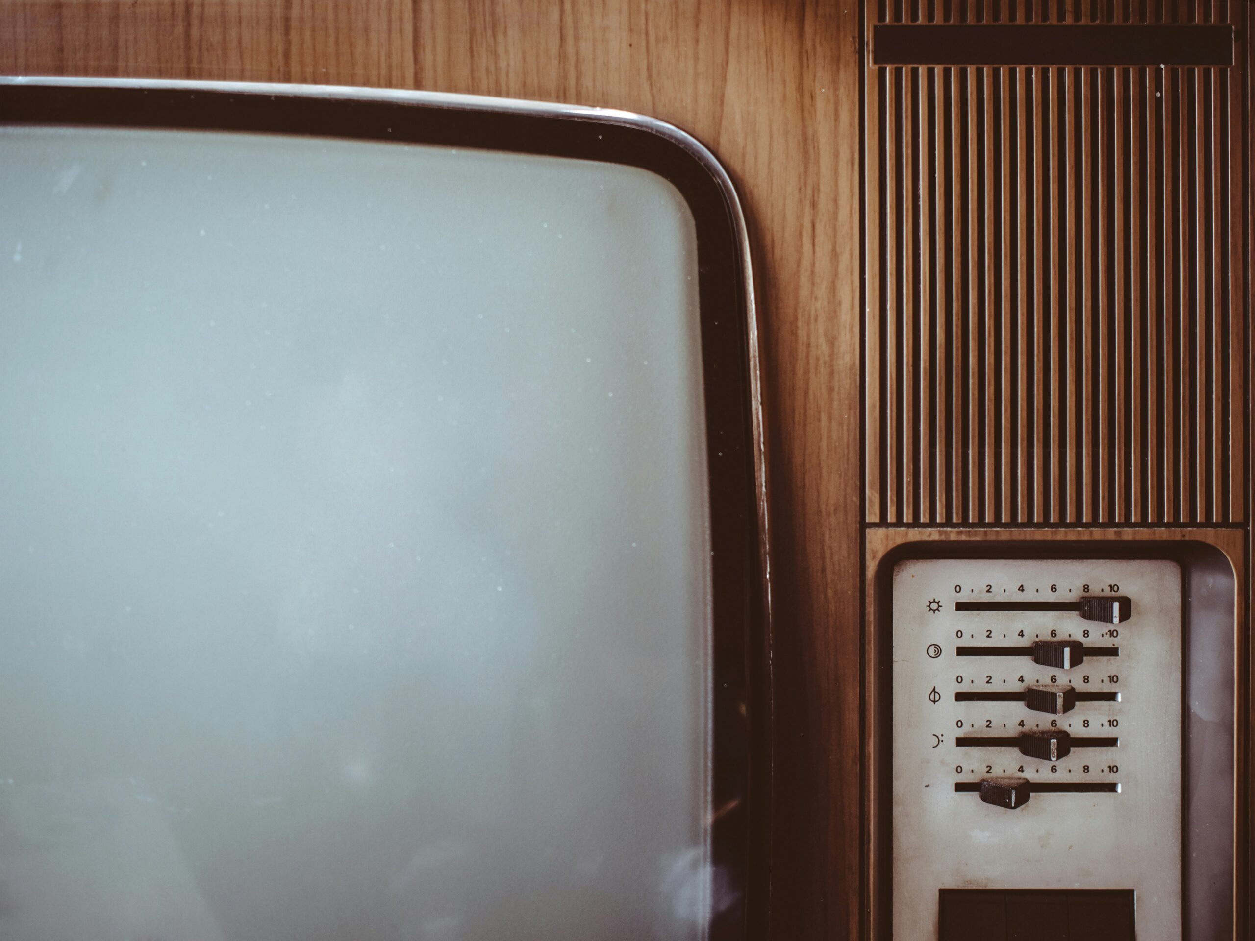 Plan centrée sur une télévision des années 80 marron avec les boutons à droite.