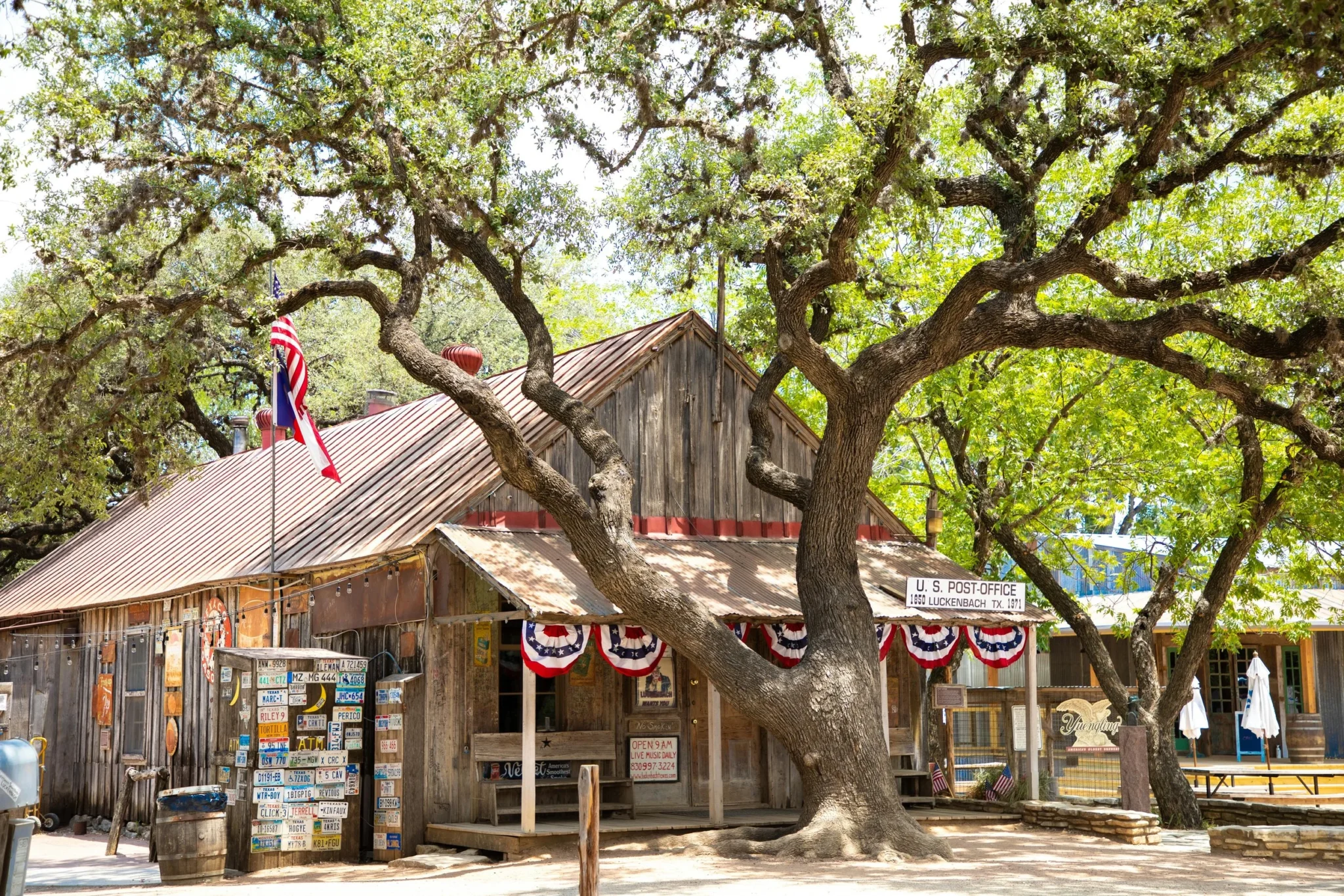 un arbre cachant la poste de Luckenbach est un célébre honky tonk texan