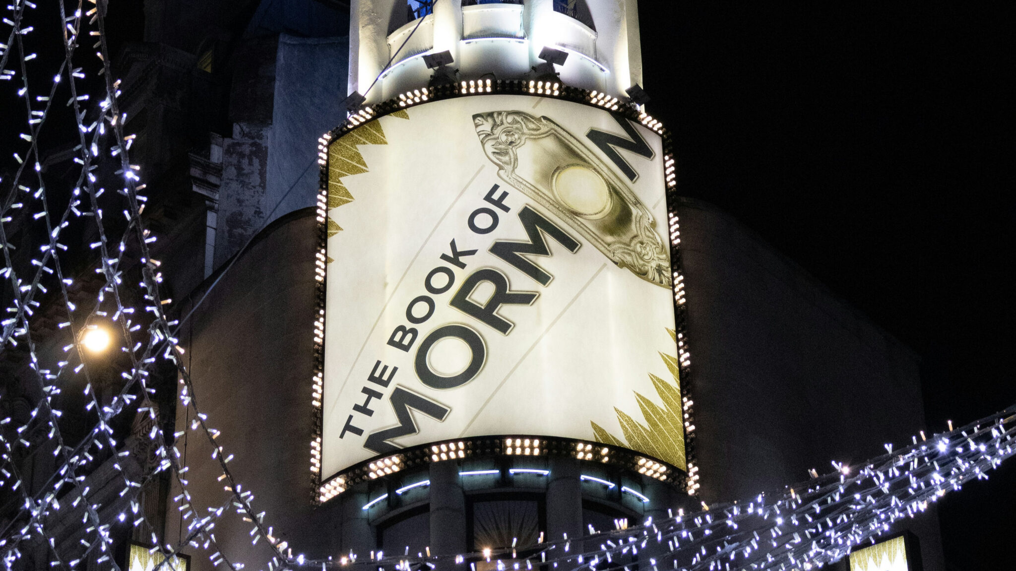 Affiche de la comédie musicale The Book of Mormon, à Broadway de nuit.