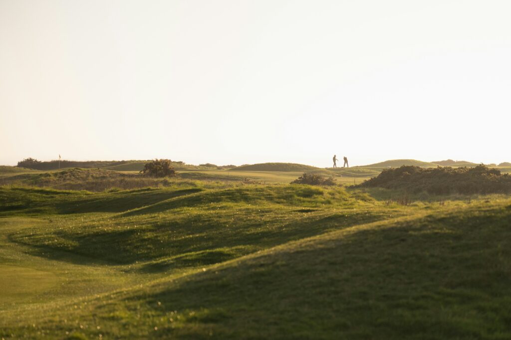 piste de golf avec 2 golfeurs au loin