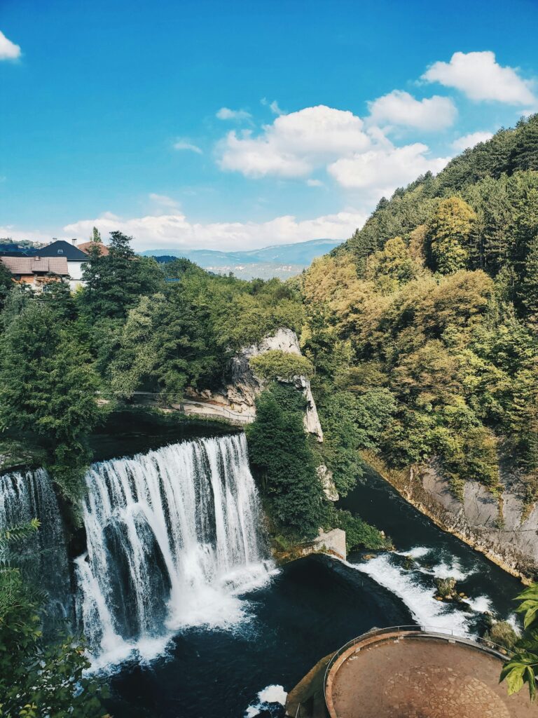 Barrage artificiel à Jajce avec la ville et les montagnes en fond.