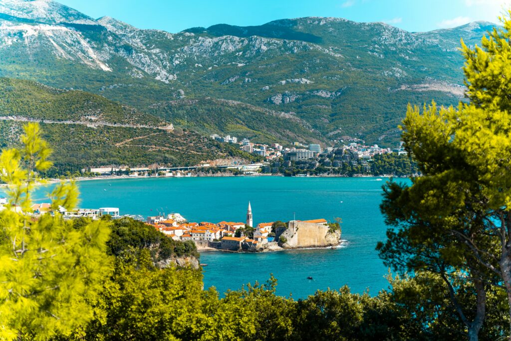 Vue à travers les arbres de bouches de kotor (ville sur les côtés d'un lac et de montagnes).