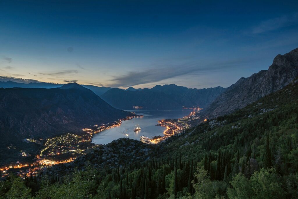 Les bouches de kotor au monténégro de nuit avec les lumières de la ville en bas des montagnes était côté du lac.