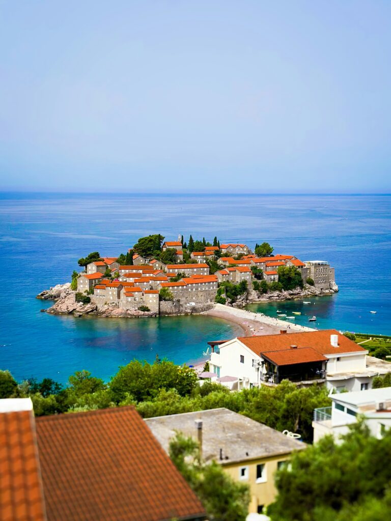 Vue de Sveti Stefan en portrait, lac, montagne et ville.