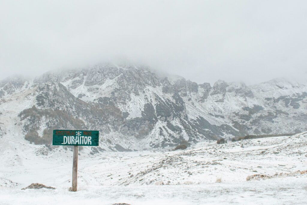 Panneau à l'entrée d'un parc national en montagne enneigée avec l'inscription " Durmitor" à Monténégro.