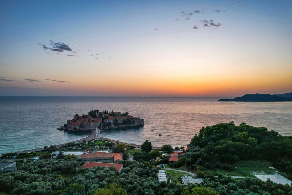 coucher de soleil à sveti stefan au Monténégro. Vue sur la mer avec une partie de la ville.