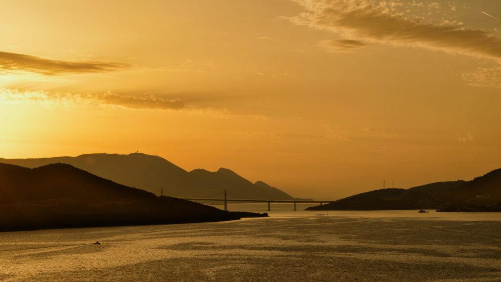 Coucher de soleil à Neum en Bosnie-Hérzégovine sur un lac entouré de montagnes.