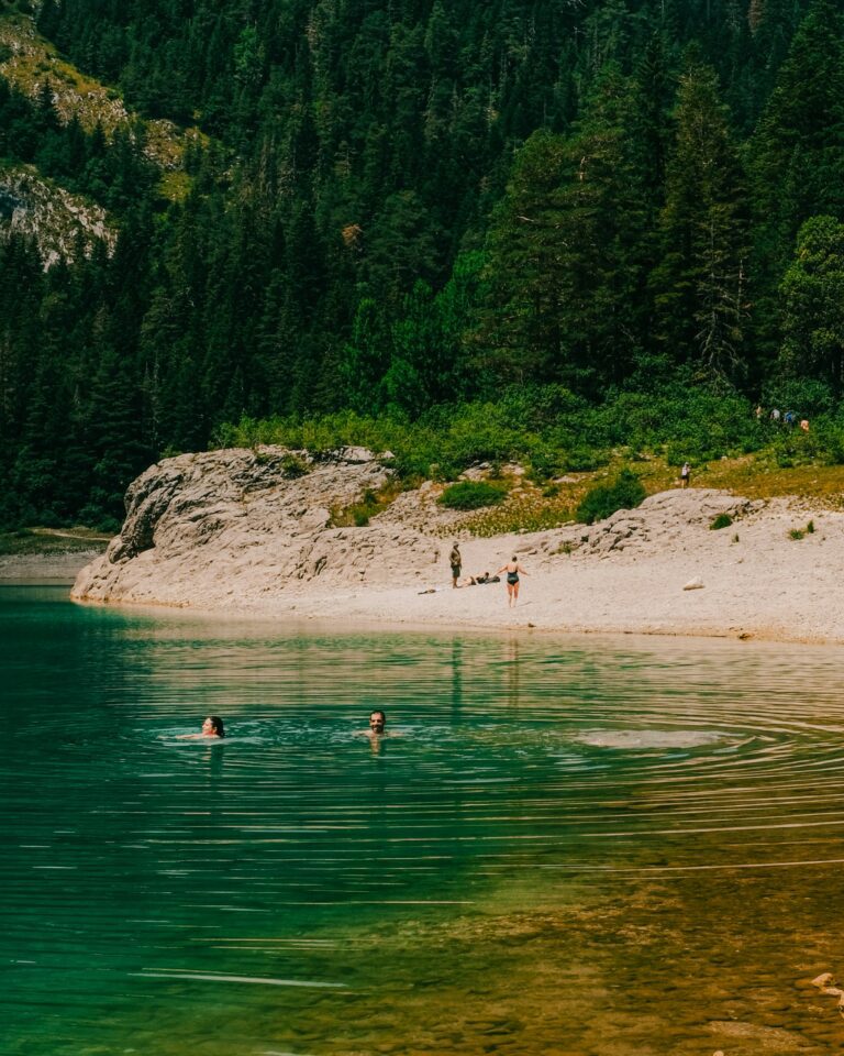 Personnes se baignants dans un lac au Monténégro, filtre couleur chaude par dessus.