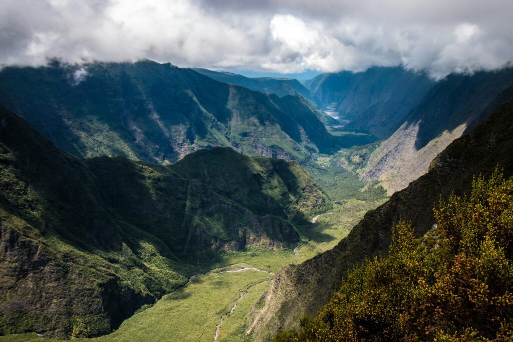Chaîne de montagnes à la Réunion avec un ruisseau passant entre 2 au sol.