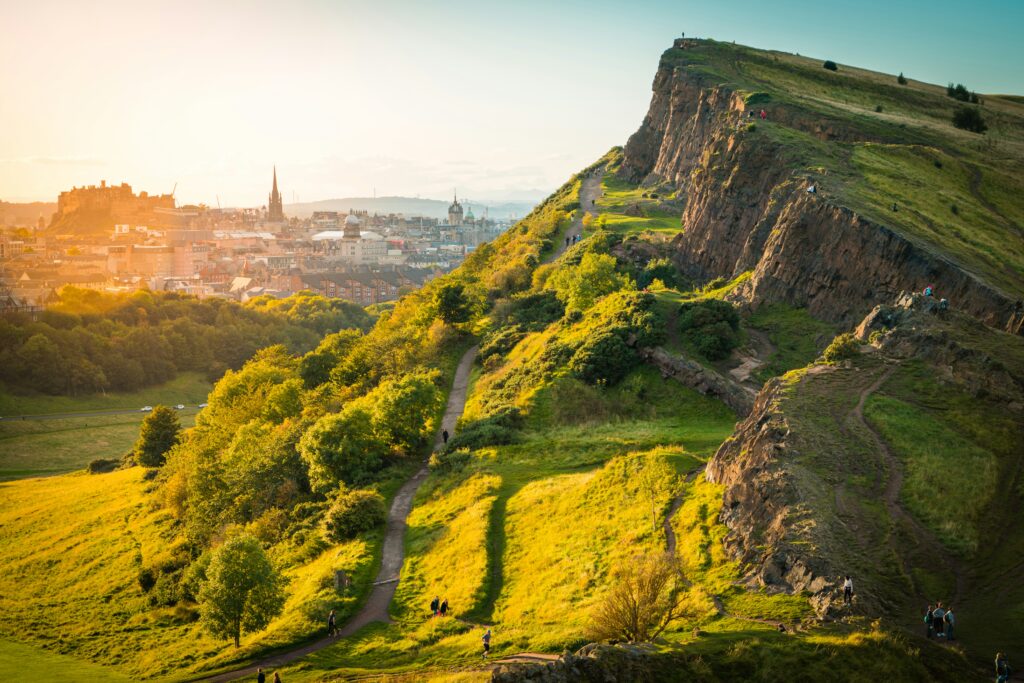 vue d'Édimbourg en fond avec en premier plan une collines avec des touristes